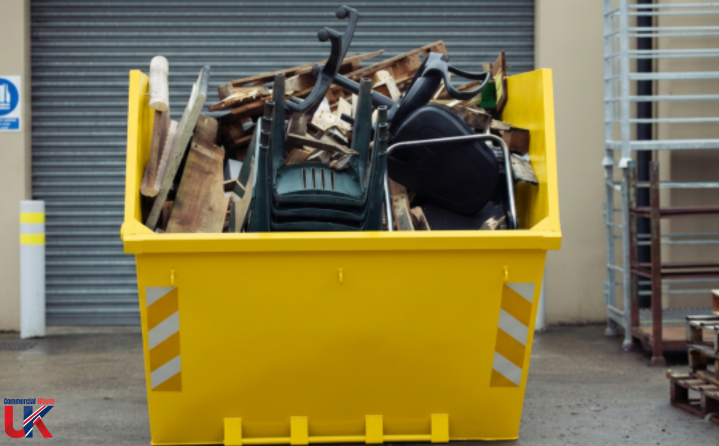 A yellow skip filled with mixed construction debris and broken materials.